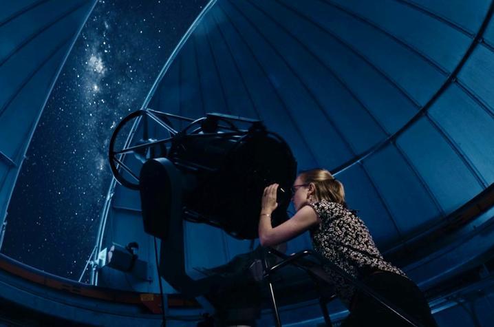 student looks through a big telescope
